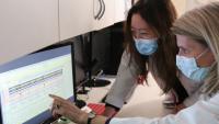 Two doctors review data on a computer screen